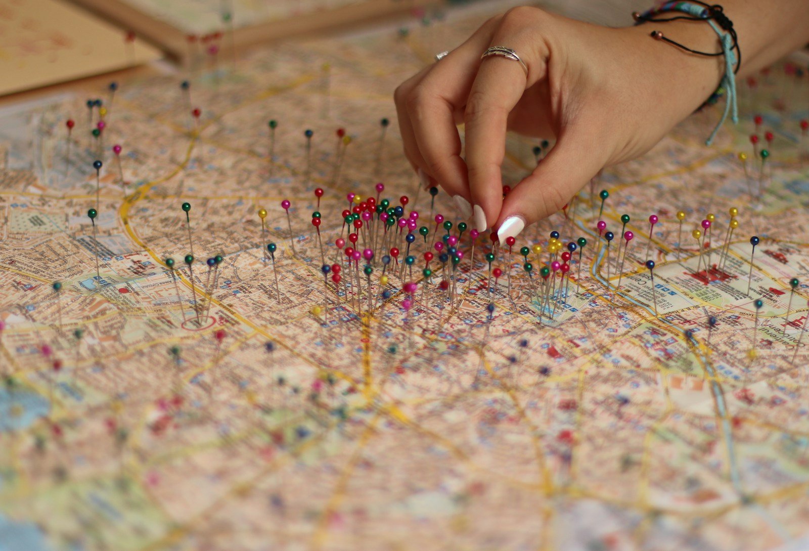 A person is putting pins on a map